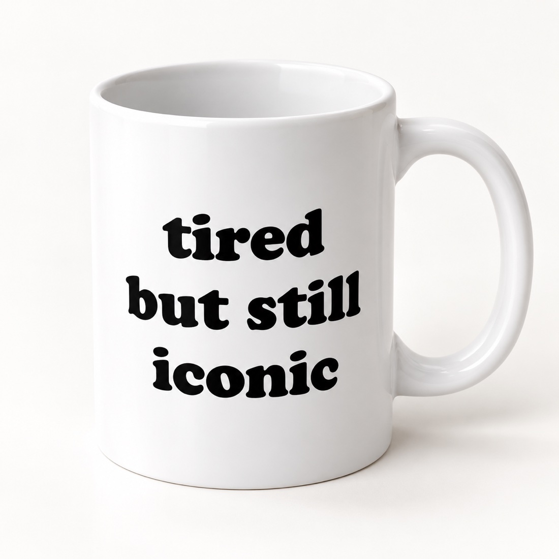 The white 11 oz ceramic mug with bold black lettering: tired but still iconic